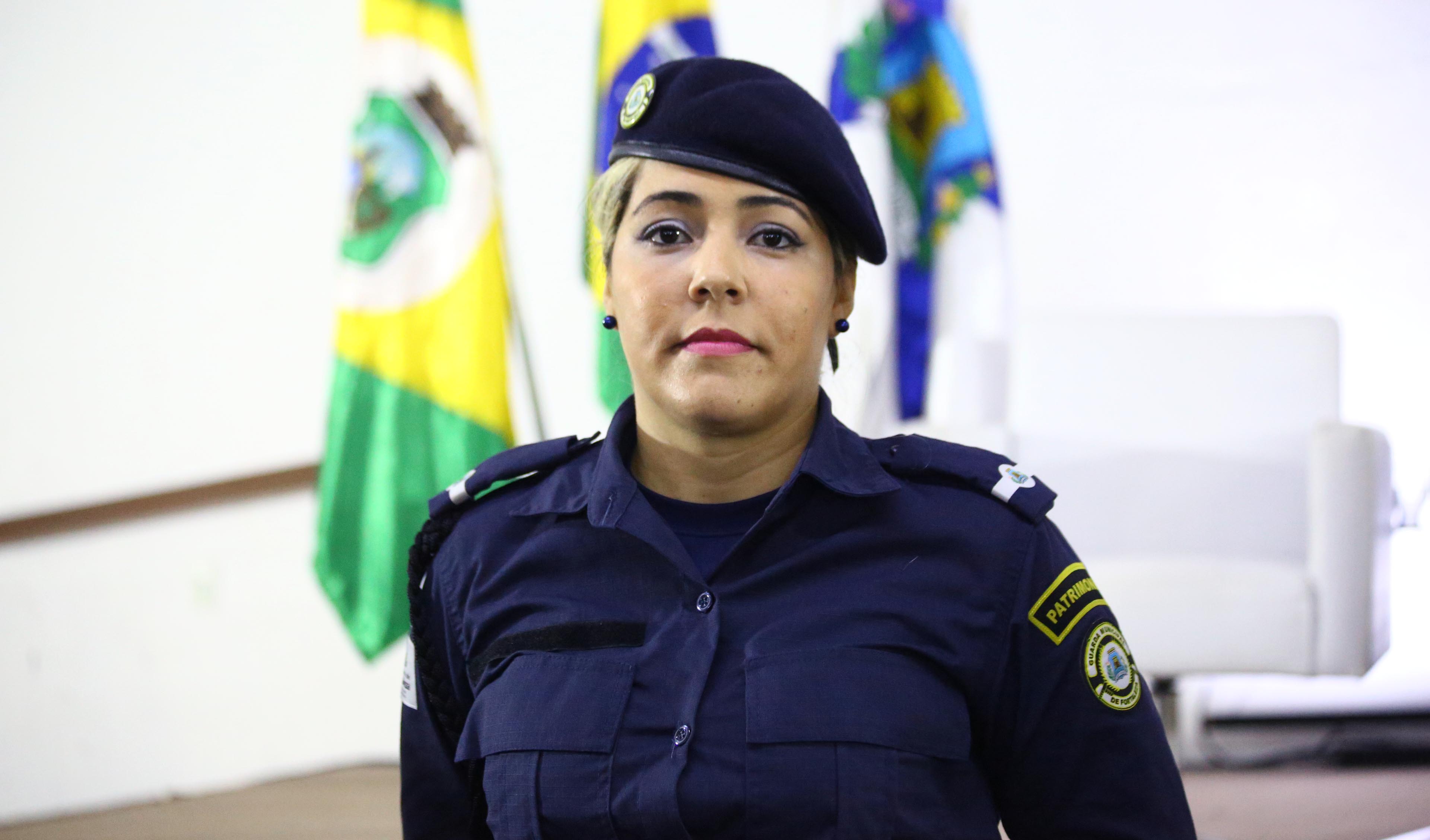 mulher com farda e boina da guarda municipal posando para a foto